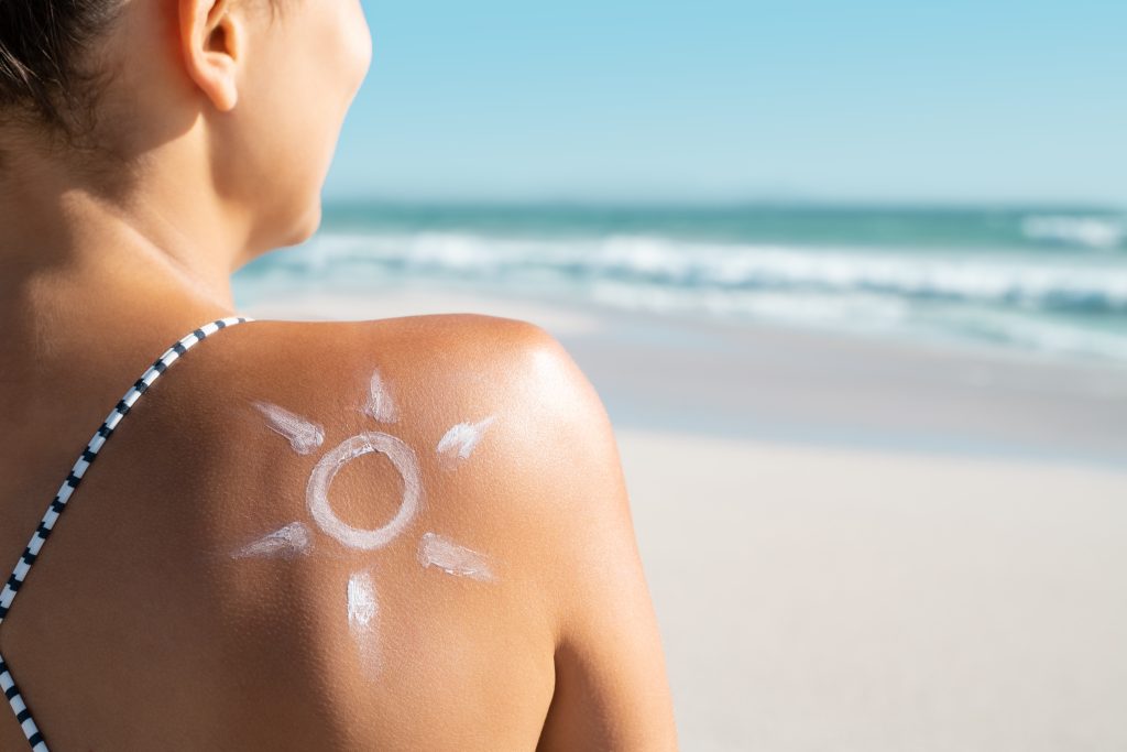 mujer con crema solar para cuidar su piel y la cicatriz de la cirugía 